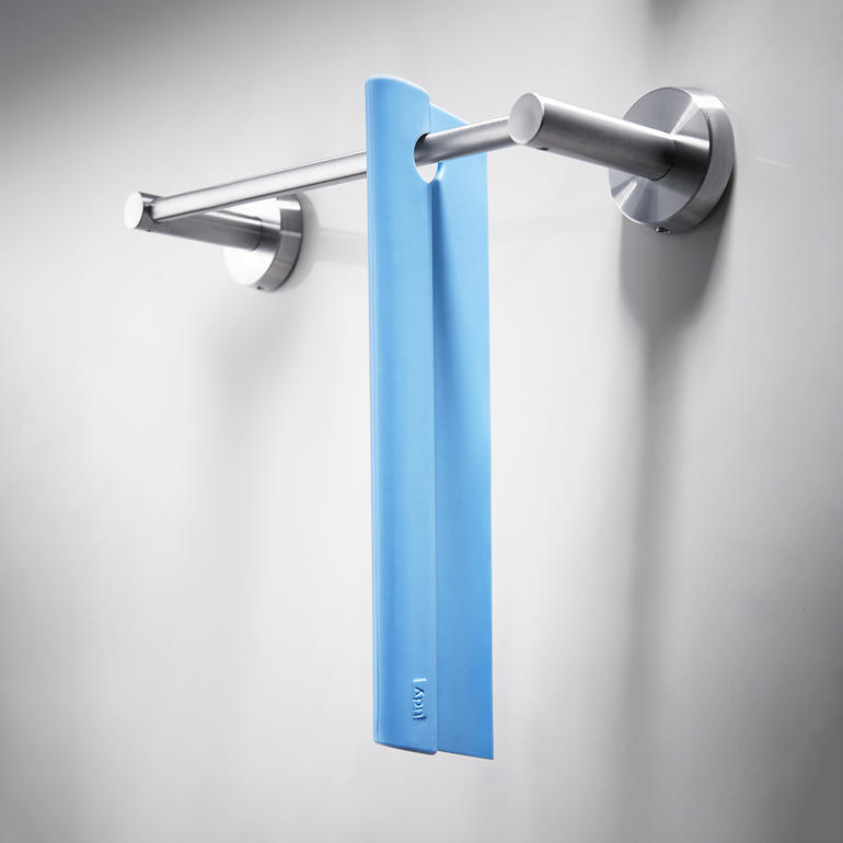 Silikonen douchetrekker hangt aan een handdoekhouder in de badkamer.