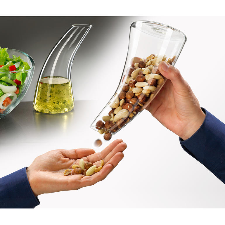 Snack-dispenser/karaf Snackdispenser in een hand om noten in de andere hand te geven.