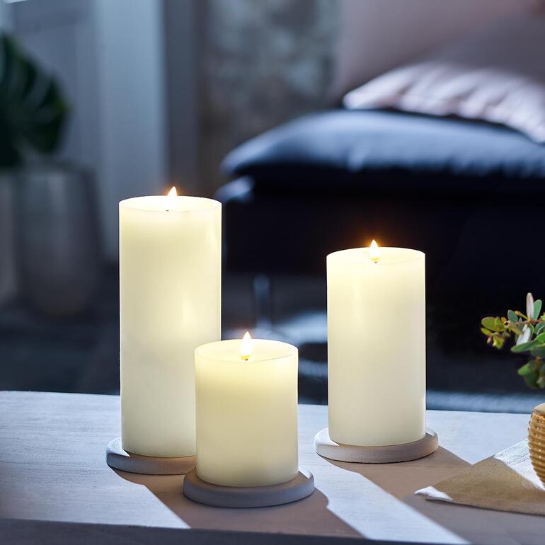 Set van drie LED-kaarsen in verschillende hoogten op een tafel.