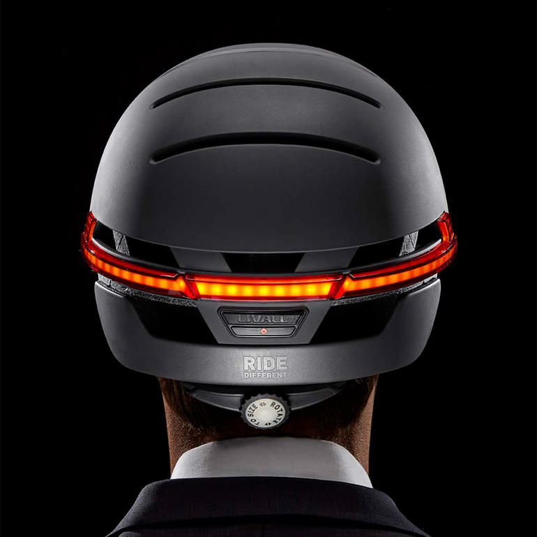 Urban design met zijdemat oppervlak en met de hand gemaakte leren klep. Achteraanzicht van een Livall BH51M slimme helm met rode LED-lampen.