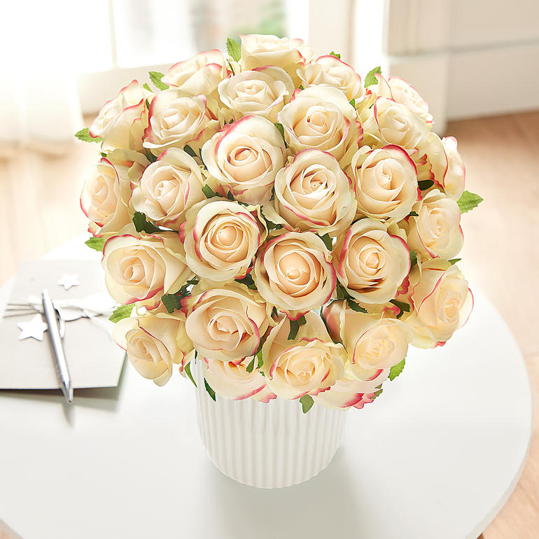 Grote bos van crèmewitte rozen in een witte pot