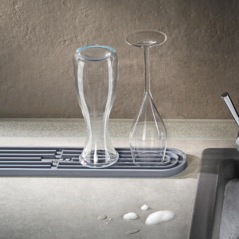 Glazen drogen op een grijze drogenmat.