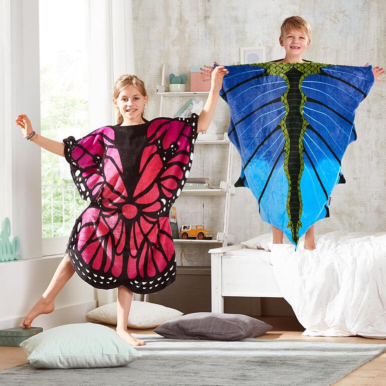 Twee kinderen in slaapdekens, één in roze en zwart, de andere in blauw en groen.