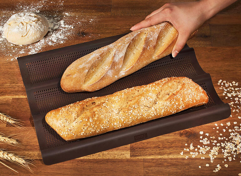 Siliconen baguette bakmat met twee vers gebakken baguettes.
