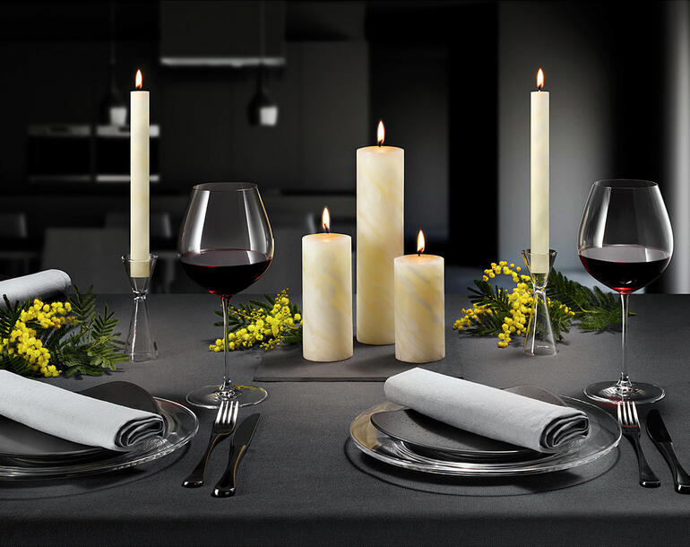 Elegante bijenwaskaarsen op een tafel voor een feestelijk diner.