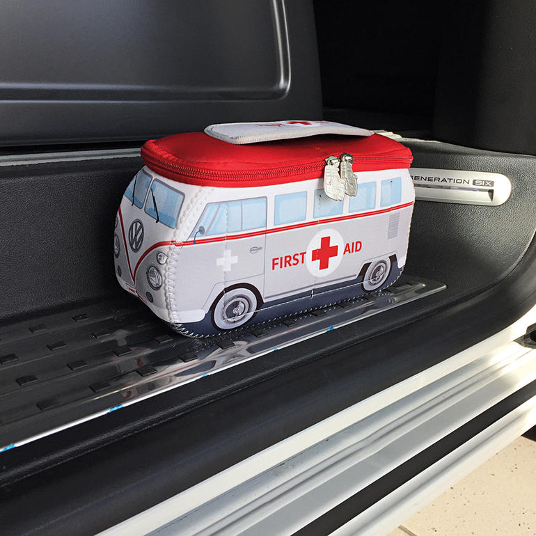 VW EHBO-set in de vorm van een VW-bus op een auto-interieur.