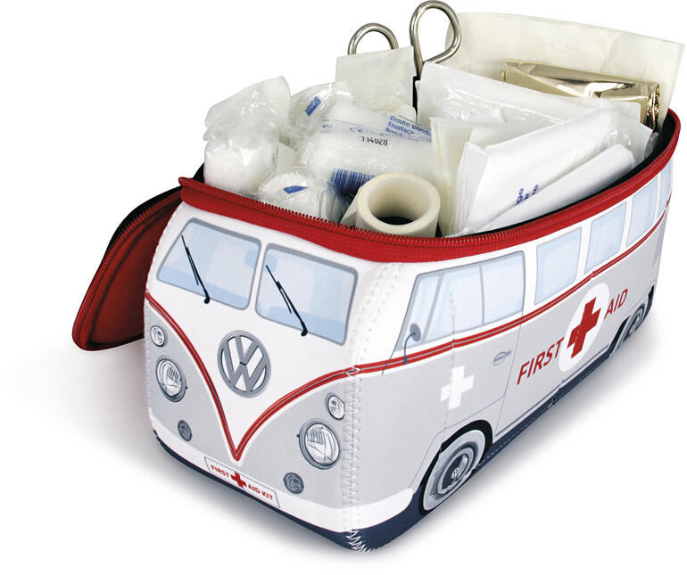 Bevat de complete eerstehulpset overeenkomstig de DIN-norm: verbandmiddelen, tape, schaar, vochtige doekjes, beschermende handschoenen, reddingsdeken, … Open VW EHBO-koffer met inhoud op een witte achtergrond.