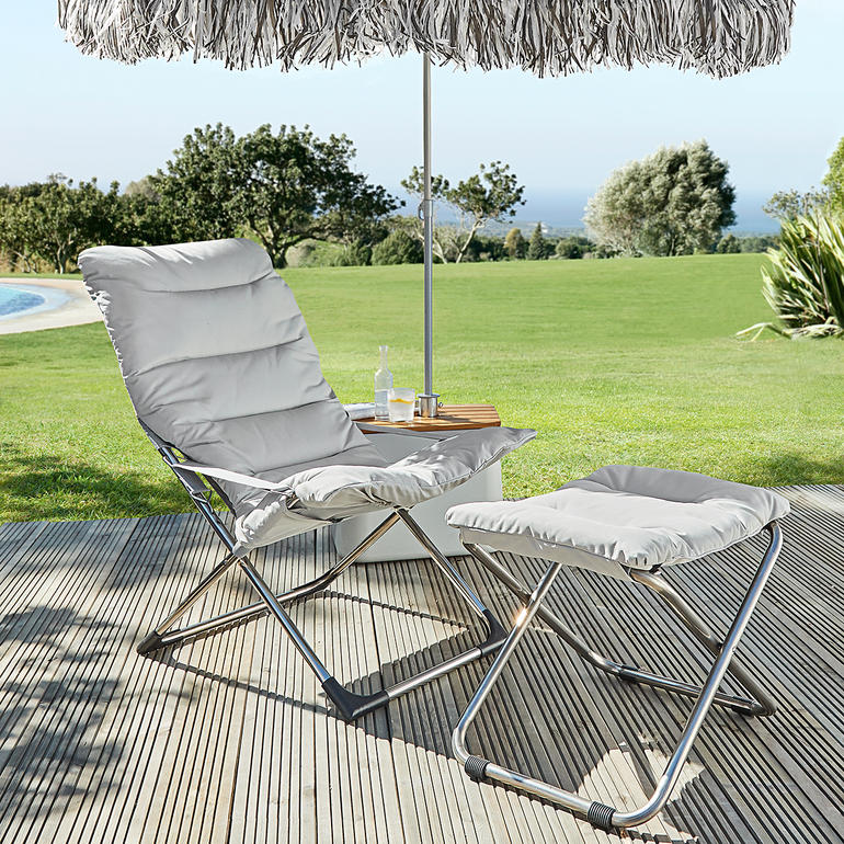 Fiam klapstoel en voetensteun op een terras met parasol.