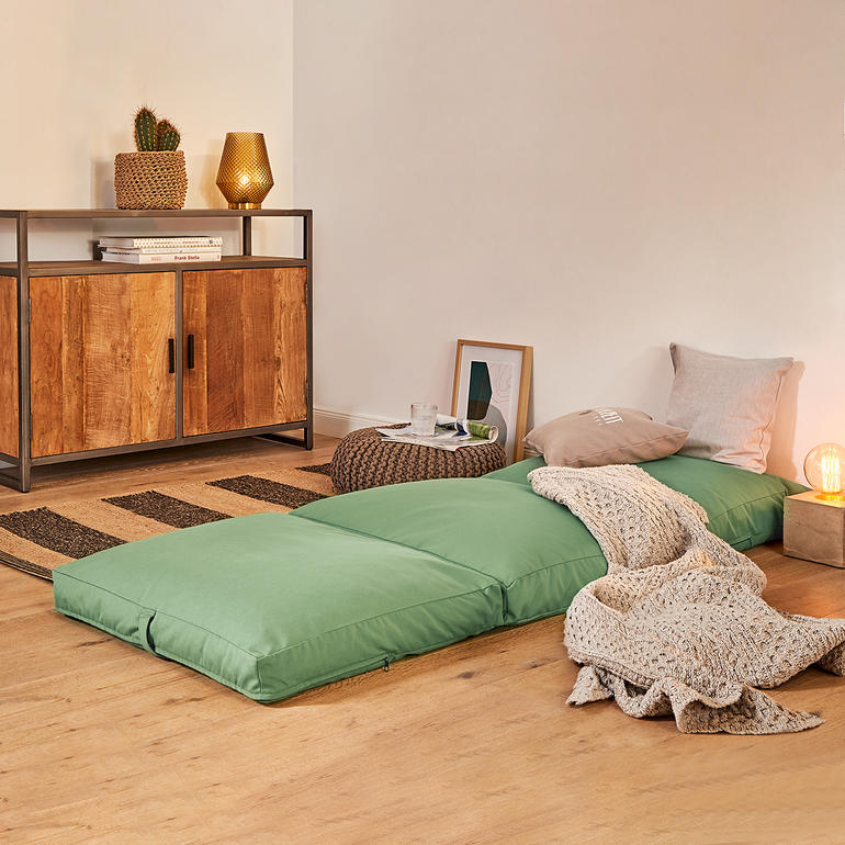 4-in-1 logeermatras uitgerold op de vloer.