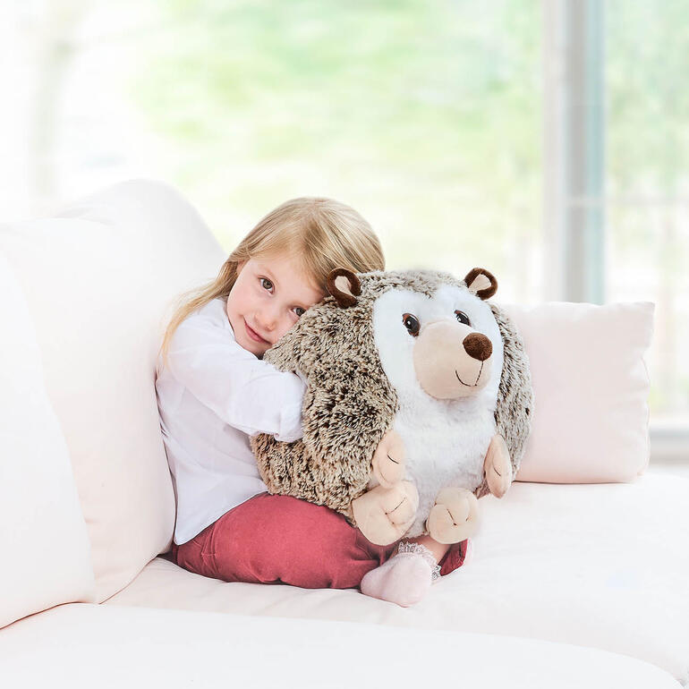 Kind knuffelt een egel handwarmtekussen in een gezellige setting