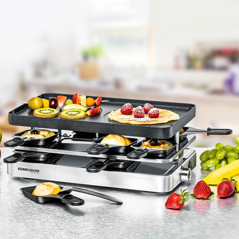 Door de gietaluminiumplaat om te draaien verandert het combi-apparaat in een crêpemaker. Kombi-Raclette RC 1400 met vers fruit en pannenkoeken op tafel.