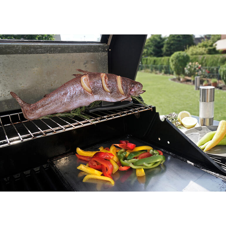 Gegrilde vis op een rooster met kleurrijke groenten