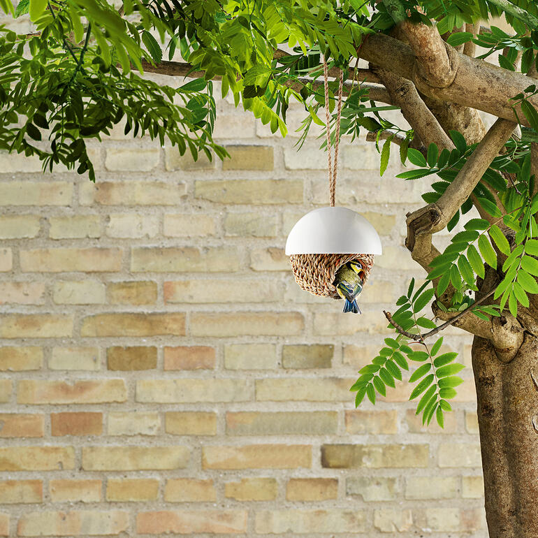 Vogelnest van zacht materiaal hangt aan een boom.