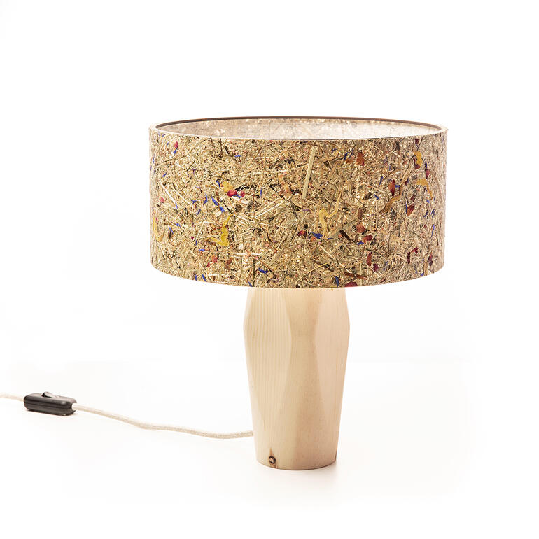 De kap is voorzien van gedroogd gras en wilde bloemen. Tafellamp van dennenhout met een decoratieve kap op een witte achtergrond