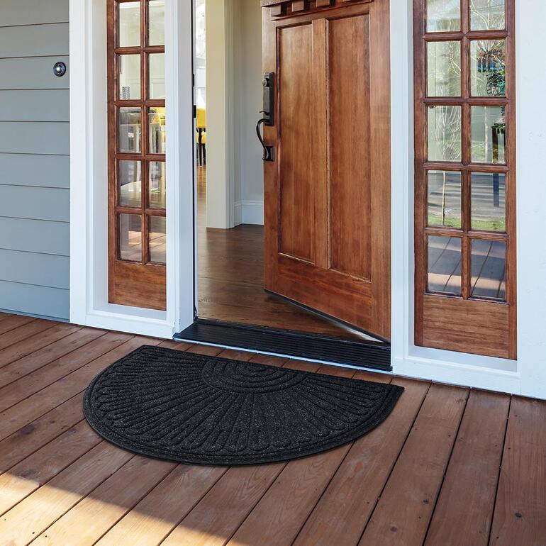 Halfronde mat van gerecycled rubber, geplaatst voor een voordeur.