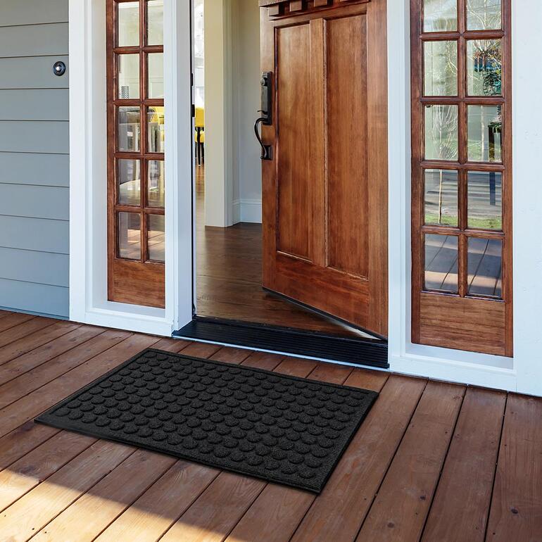 Rechthoekige mat van gerecycled rubber, geplaatst voor een kinderkamerdeur.