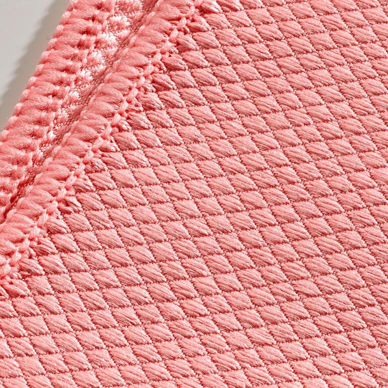 De speciale weefstructuur maakt de bioactieve microvezeldoekjes zeer absorberend. Close-up van een roze vetweg-poetsdoek van stof.