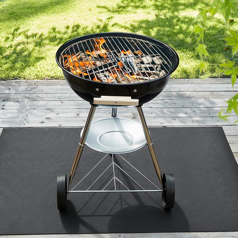 Grill op een recycle-bodembeschermmat buiten.