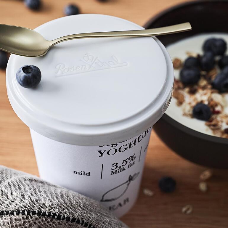 Rosenthal vershouddeksel op een yoghurtbeker met verse bessen.