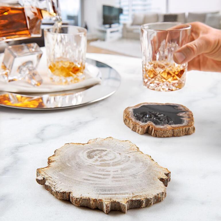 Houten onderzetters op tafel met een whiskyglas.