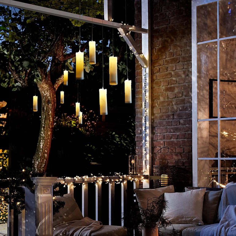 Ook een magische blikvanger op uw terras of in de tuin. Hangende LED-kaarsen op een terras met lichtjes.