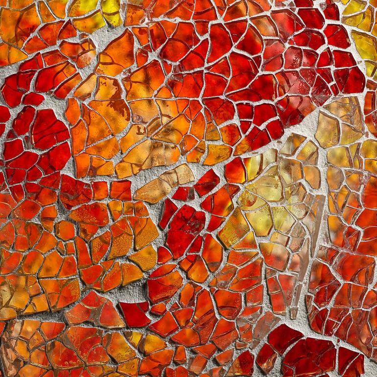 Ook overdag een decoratieve blikvanger. Kleurige glasstukjes in rood en oranje voor de tuinbal.