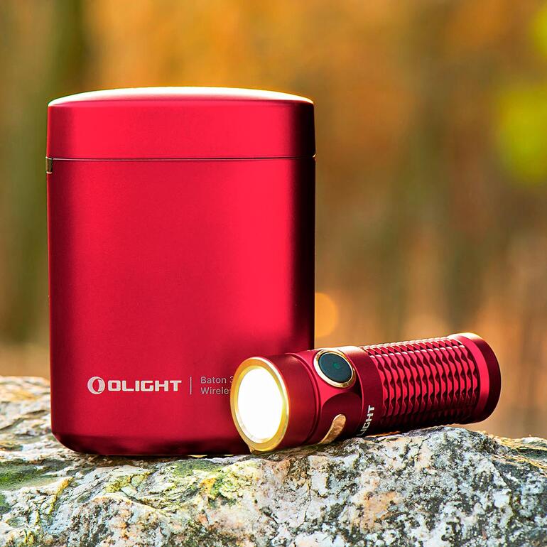 Olight Baton 3 zaklamp met rode oplader op een steen