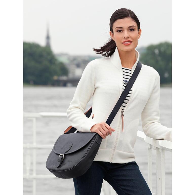 Vrouw met zwarte stewardess tas aan het water.