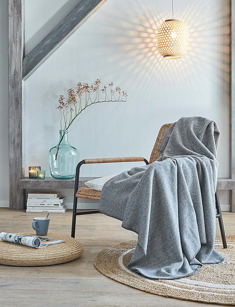 Wollen fleece deken op een stoel in een moderne woonkamer.