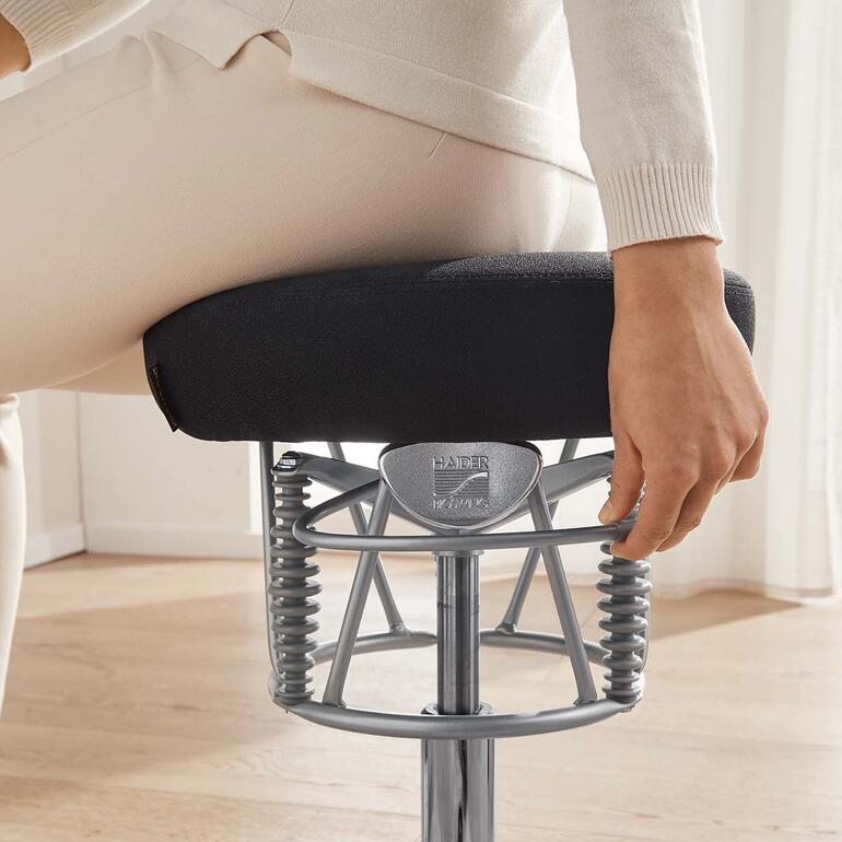 Of u zich naar voren, naar achteren of opzij beweegt – Bioswing ondersteunt elke positie perfect. Detailopname van de hand van een vrouw die een regelaar op de ergonomische stoel aanpast.
