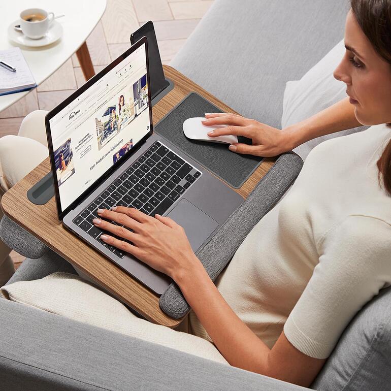 Vrouw zit met een laptop op een comfortabel leeskussen.