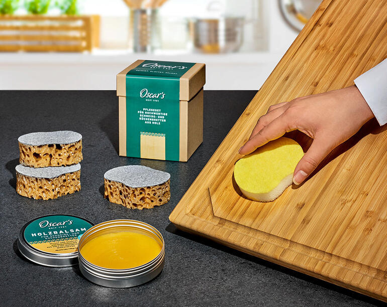 Oscar's houtverzorgingset met reinigings- en verzorgingsmaterialen op een houten snijplank.