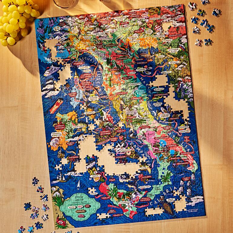 Onvoltooid wijnpuzzel met veel puzzelstukken op een houten tafel.