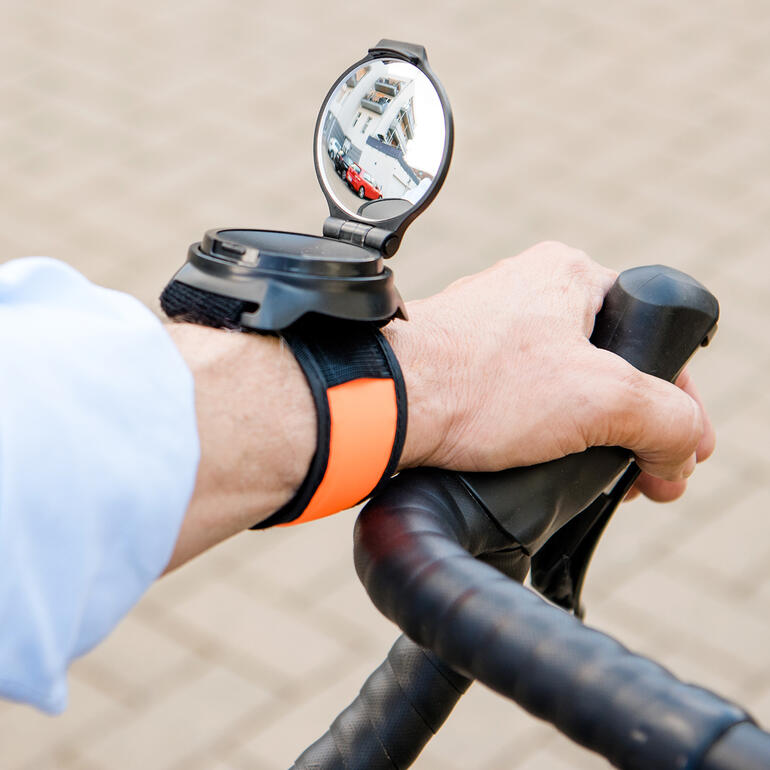Fietsspiegel aan de pols met een lichtarmband.