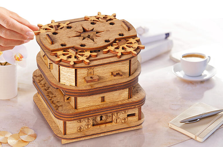 Houten doos met meerdere speelstukken en puzzels op het deksel.