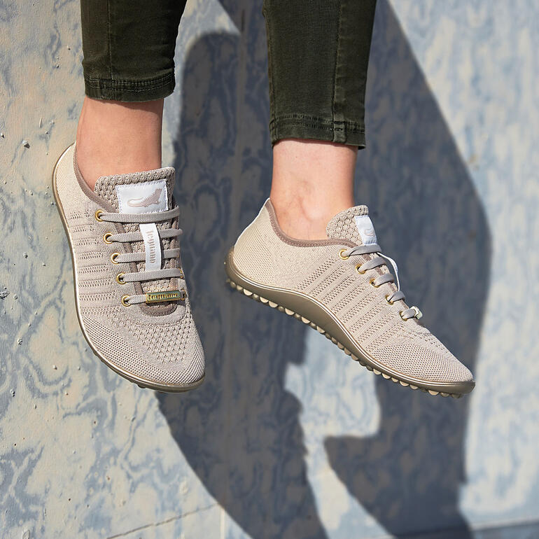 Barfuß-leguano Sneaker in beige, in de lucht hangend.