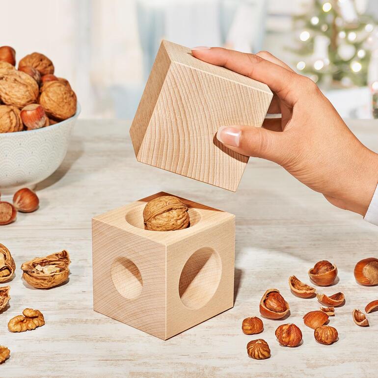 Houten nootjes met een walnoot op een tafel.