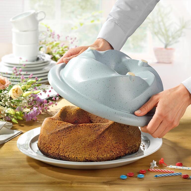 Kok laat de CeraFlam Gugelhupfvorm zien met vers gebakken cake.