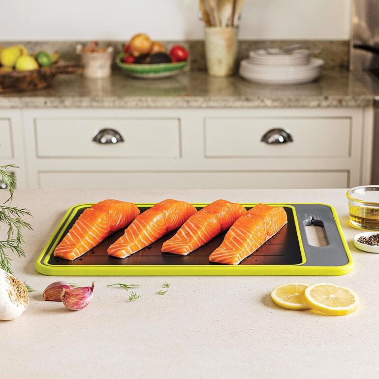Zalmfilets op een keukentafel en snijplank.