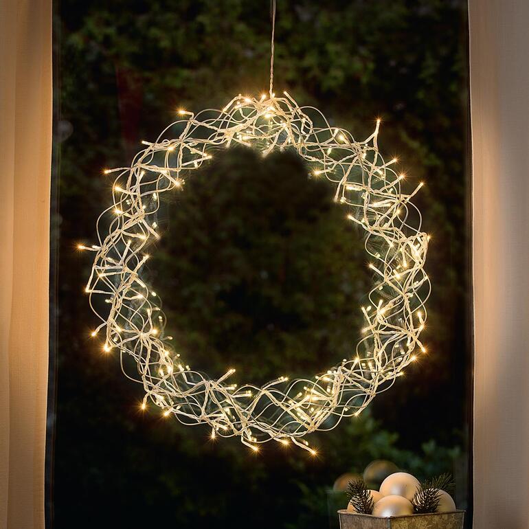 LED-decoratiekrans met verlichte lichten in een raam.