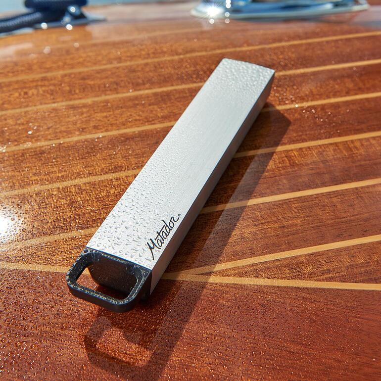 Waterdichte pillendoos op een houten tafel van een boot met waterdruppels.