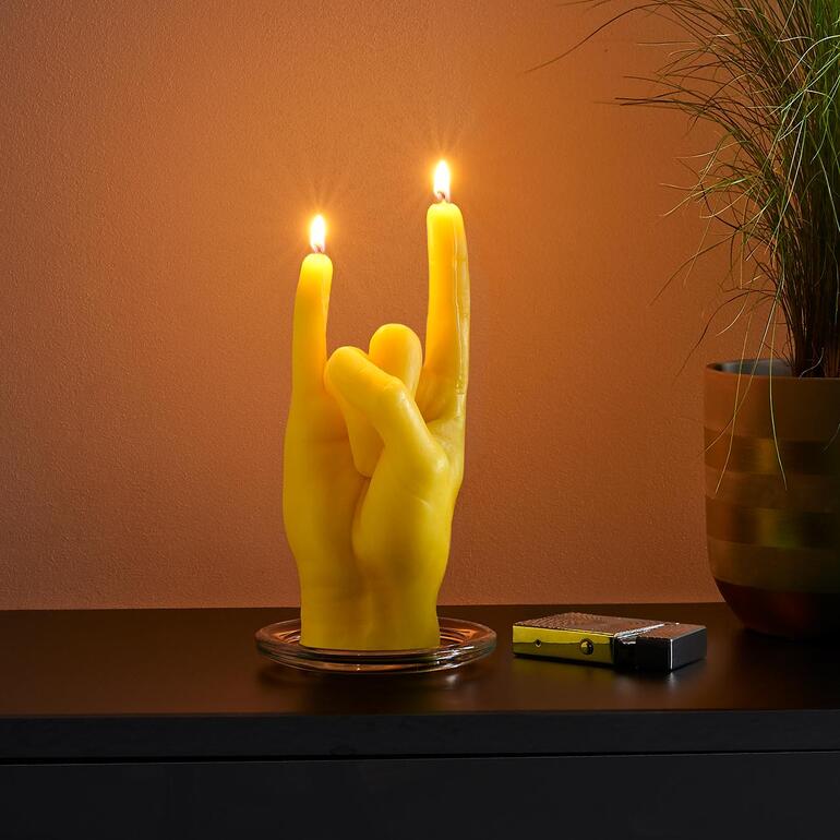 Rock you, geel Gele handgebaarthenkaars in een rockgeste op een tafel.