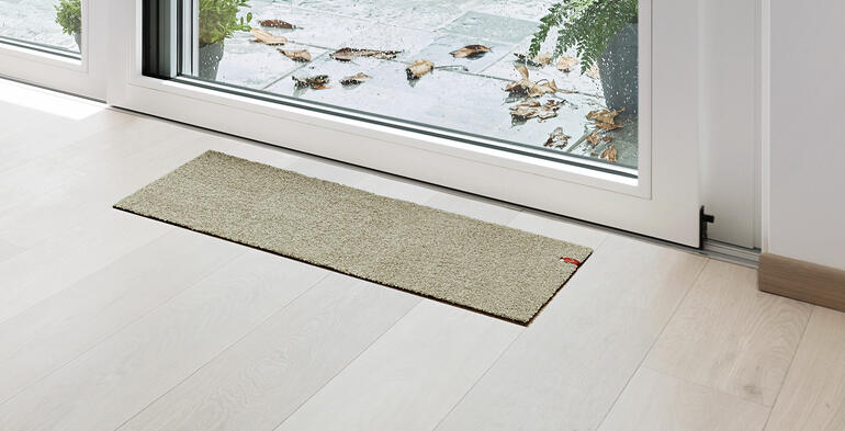Terrasdeur mat in beige voor een glazen deur.