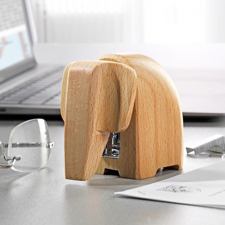 Houten nietmachine in de vorm van een olifant op een bureau.