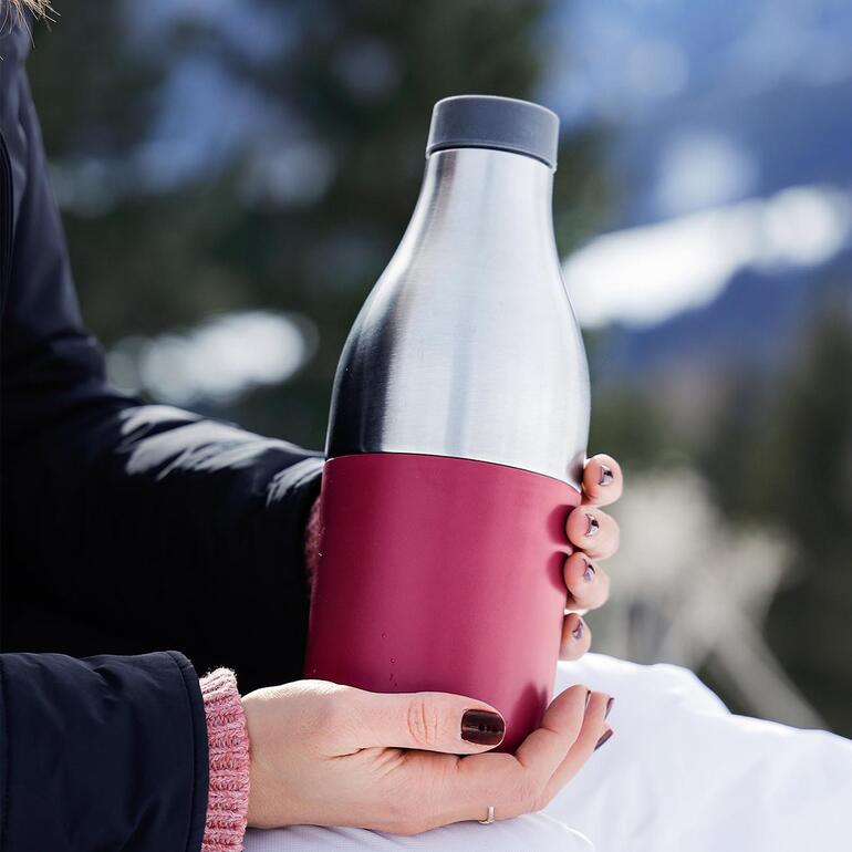 2-in-1 lunchbox/drinkfles Persoon houdt de 2-in-1 lunchcontainer en drinkfles buiten vast.