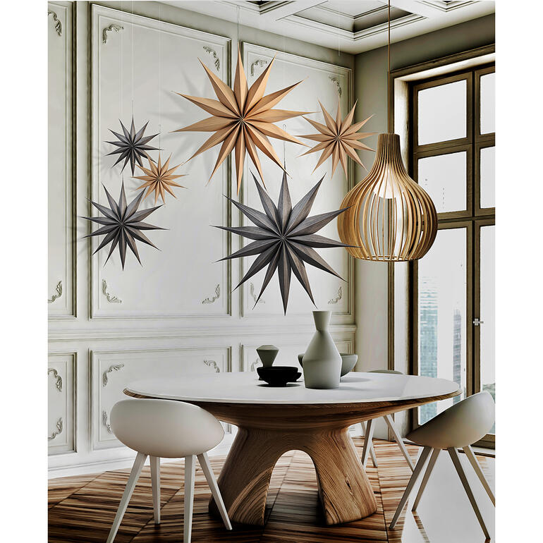 Houten kerststerren hangen boven een tafel in een moderne kamer.