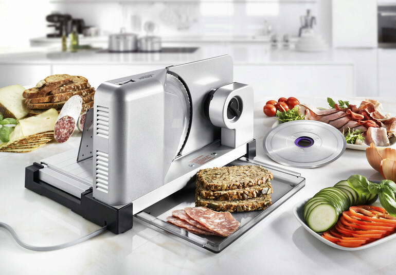 Allesschneider icaro 5 Duo Plus met verschillende voedingsmiddelen op een tafel.