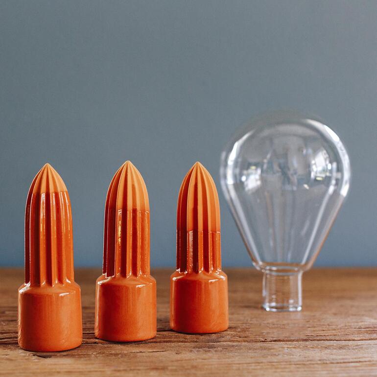 1 terracotta kegel incl. glazen reservoir in elke set. Diverse onderdelen van het universele bewateringssysteem op een houten oppervlak