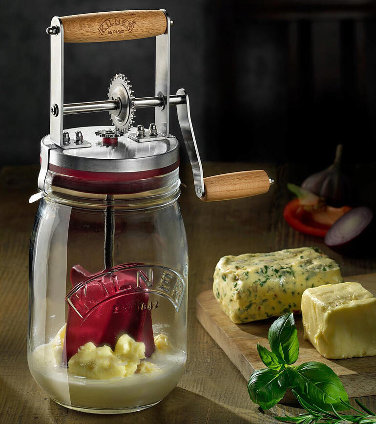 Boterpot met handkurbel op een houten tafel met boter