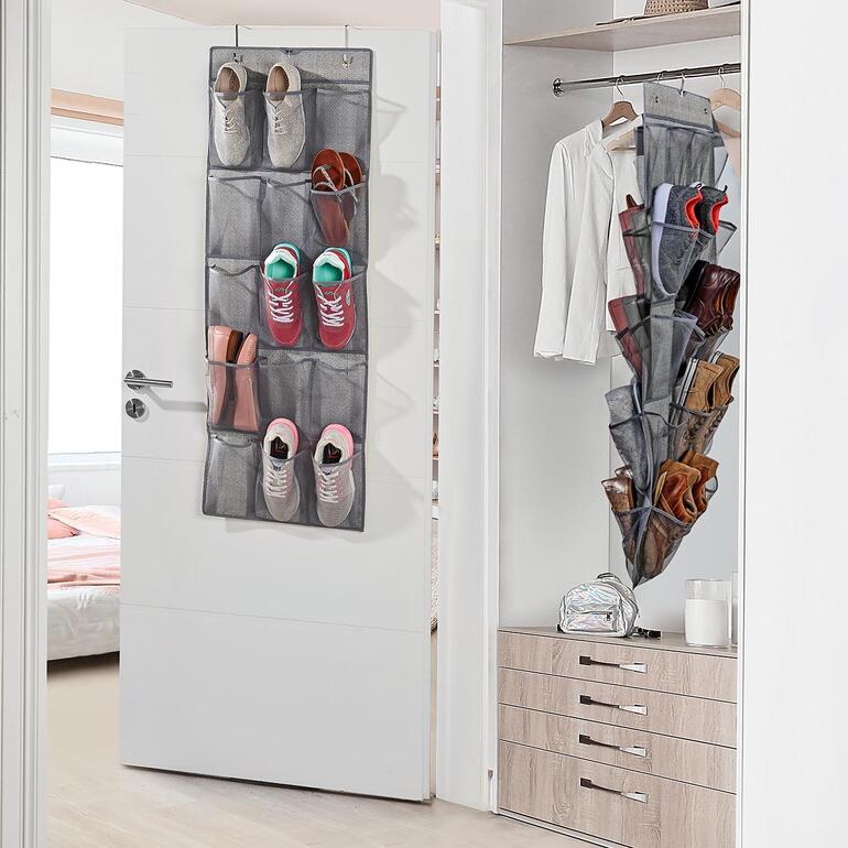 Tweedelige schoenenorganizer hangt aan een deur met schoenen in verschillende vakken.